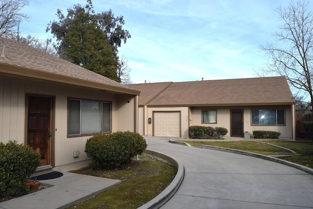 ranch-style house with a garage, a front lawn, and concrete driveway