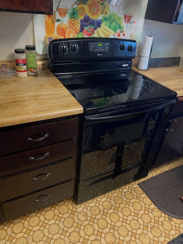 kitchen featuring dark brown cabinets, black / electric stove, and light countertops