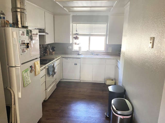 kitchen with white appliances, white cabinets, dark wood-type flooring, light countertops, and a sink