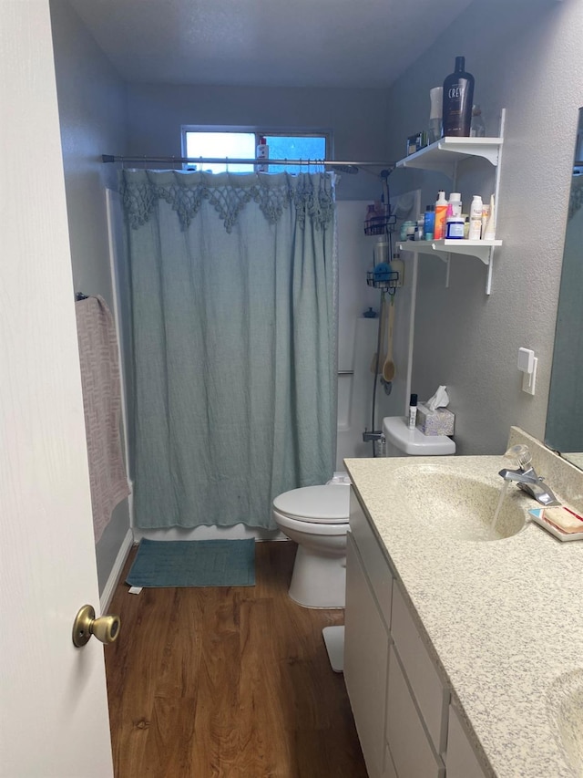 full bathroom with shower / tub combo with curtain, vanity, toilet, and wood finished floors