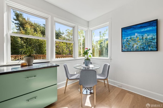 dining space with light wood-style floors and baseboards