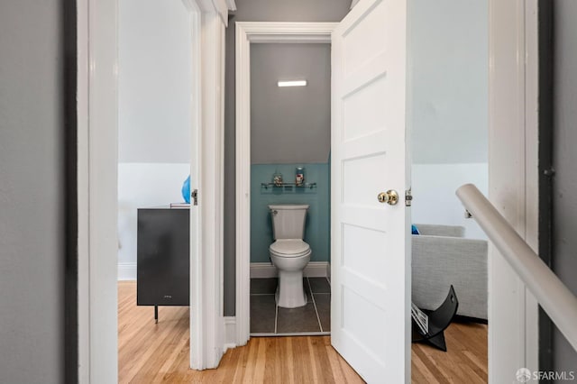 bathroom featuring wood finished floors, toilet, and baseboards