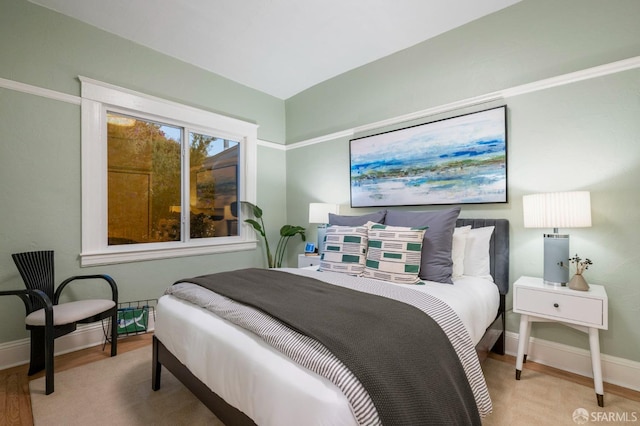 bedroom with baseboards and wood finished floors