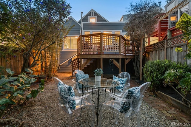 back of house featuring a deck, outdoor dining area, stairway, and fence