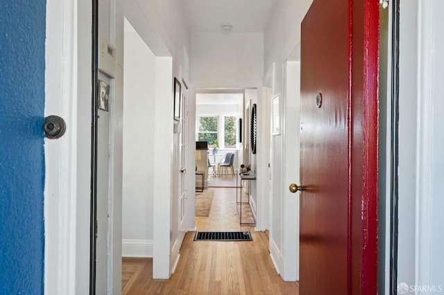 corridor with baseboards and wood finished floors