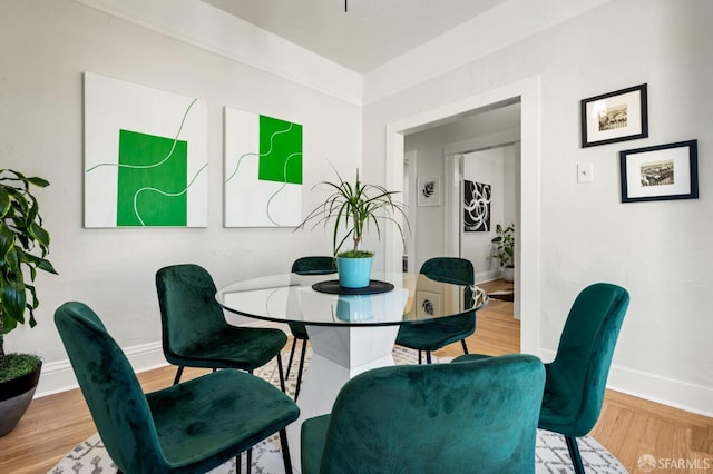 dining space featuring wood finished floors and baseboards