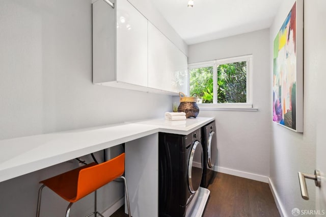 laundry room with dark wood-style floors, separate washer and dryer, cabinet space, and baseboards