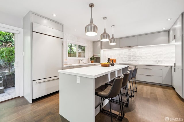 kitchen featuring a kitchen island, modern cabinets, white built in refrigerator, gray cabinets, and light countertops