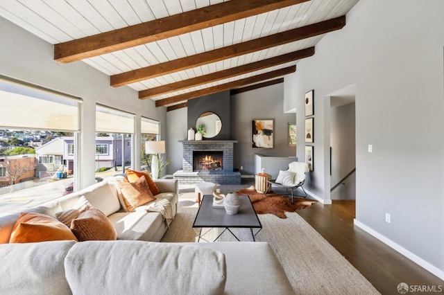 living area featuring beam ceiling, a fireplace, wood ceiling, wood finished floors, and baseboards