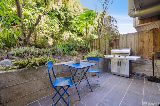 view of patio featuring outdoor dining space, area for grilling, and fence