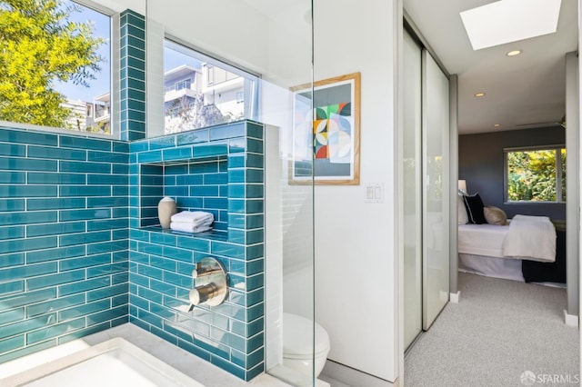 ensuite bathroom with a skylight, a healthy amount of sunlight, ensuite bath, and tiled shower