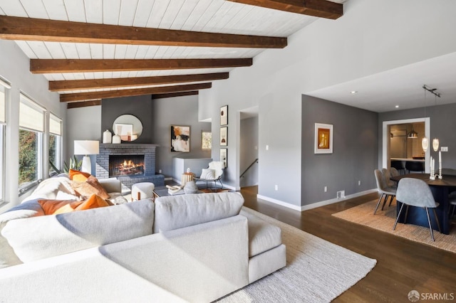 living room featuring lofted ceiling with beams, wood ceiling, a brick fireplace, wood finished floors, and baseboards