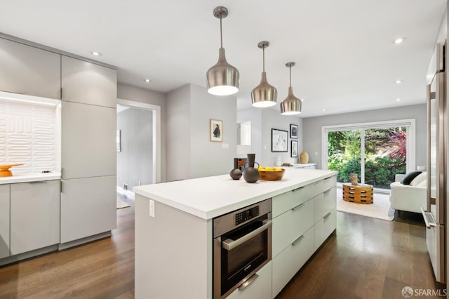 kitchen featuring dark wood-style floors, light countertops, oven, and recessed lighting