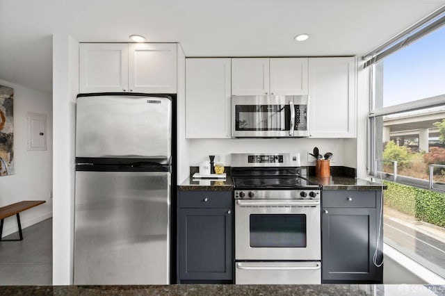 kitchen with white cabinetry, appliances with stainless steel finishes, dark stone countertops, and gray cabinetry