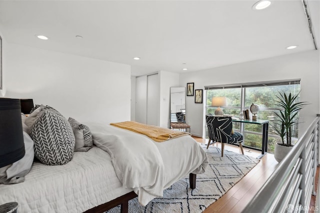 bedroom featuring access to outside, light hardwood / wood-style floors, and a closet