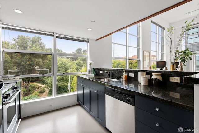 kitchen featuring sink, dark stone countertops, stove, stainless steel dishwasher, and oven