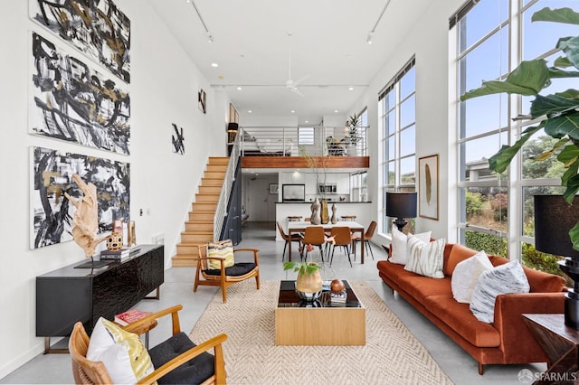 living room featuring rail lighting and a high ceiling