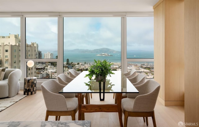 1070 Green St Unit 801, San Francisco, CA 94133 - dining room featuring healthy amount of natural light, wood finished floors, a water view, and a wall of windows