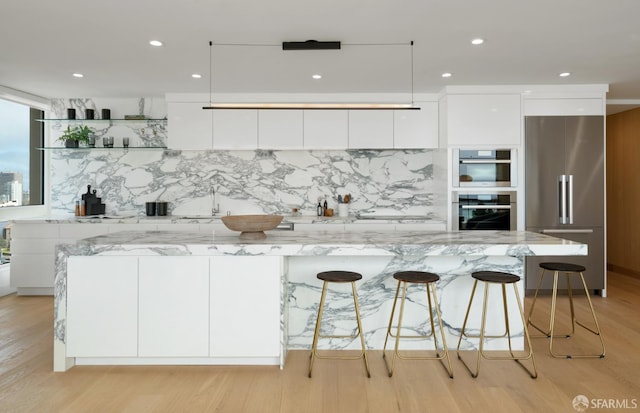 1070 Green St Unit 801, San Francisco, CA 94133 - kitchen featuring appliances with stainless steel finishes, modern cabinets, white cabinetry, tasteful backsplash, and light wood-style flooring