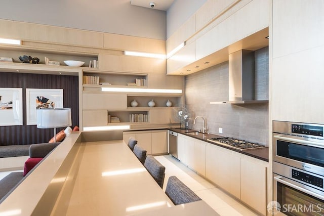 kitchen with sink, white cabinetry, stainless steel appliances, decorative backsplash, and wall chimney range hood