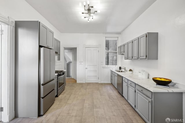 kitchen featuring light wood-type flooring, appliances with stainless steel finishes, sink, and gray cabinets