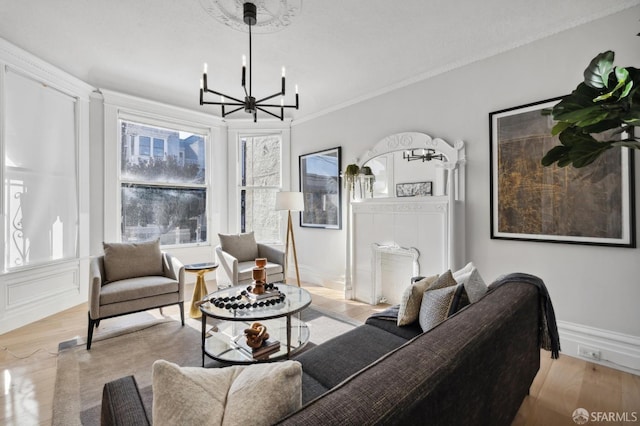 living room featuring light hardwood / wood-style floors, ornamental molding, a notable chandelier, and a healthy amount of sunlight