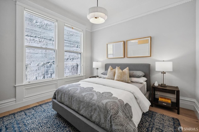 bedroom with hardwood / wood-style flooring and crown molding