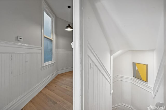 stairway with vaulted ceiling and hardwood / wood-style floors