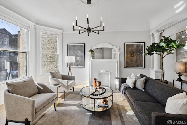 living room featuring light wood-type flooring, a notable chandelier, crown molding, and ornate columns