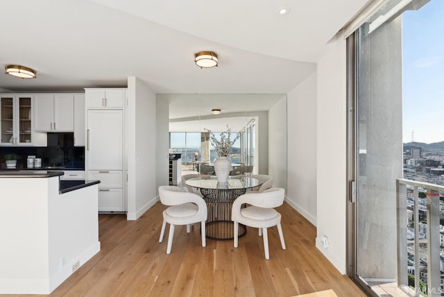 dining room featuring a wealth of natural light, recessed lighting, light wood-style flooring, and baseboards