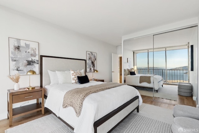 bedroom featuring access to outside and wood finished floors