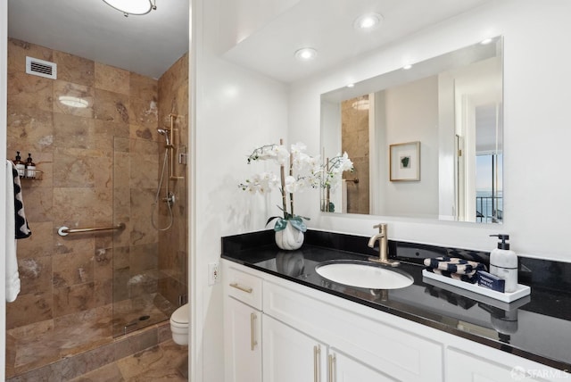 bathroom featuring visible vents, toilet, vanity, a shower stall, and recessed lighting