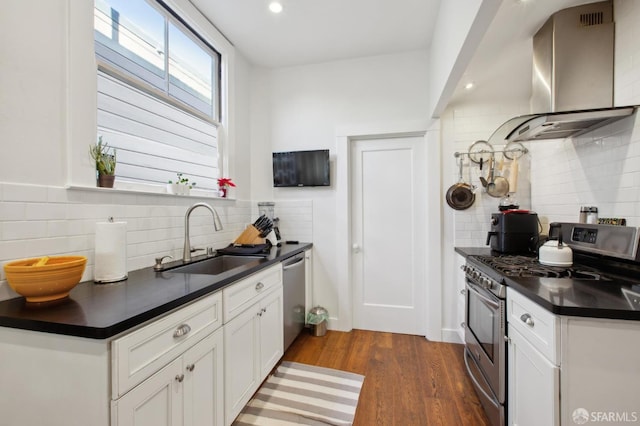 kitchen with stainless steel appliances, dark wood-type flooring, wall chimney exhaust hood, sink, and white cabinetry