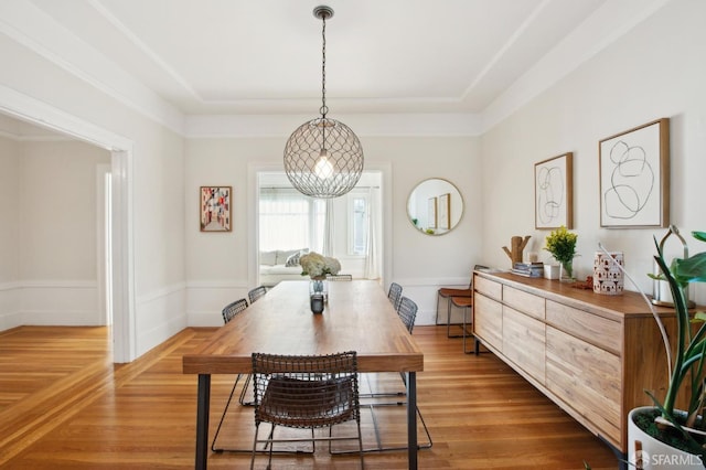 dining area featuring a tray ceiling and wood-type flooring