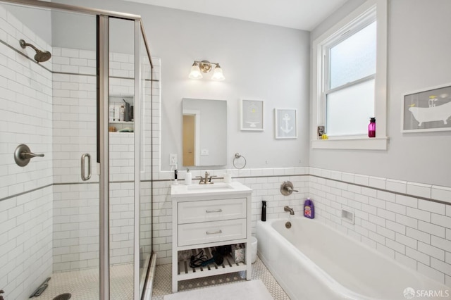 bathroom with tile walls, vanity, tile patterned floors, and separate shower and tub