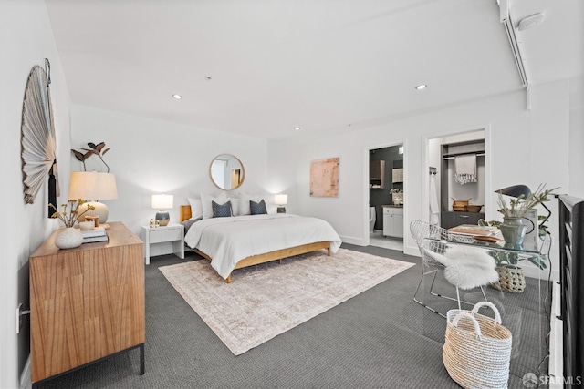 bedroom featuring ensuite bath and dark colored carpet