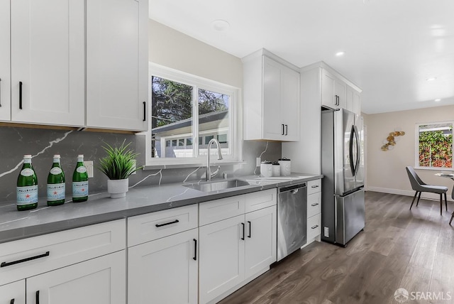 kitchen with white cabinets, sink, dark hardwood / wood-style floors, decorative backsplash, and stainless steel appliances