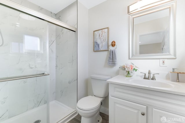 bathroom featuring vanity, toilet, and a shower with shower door