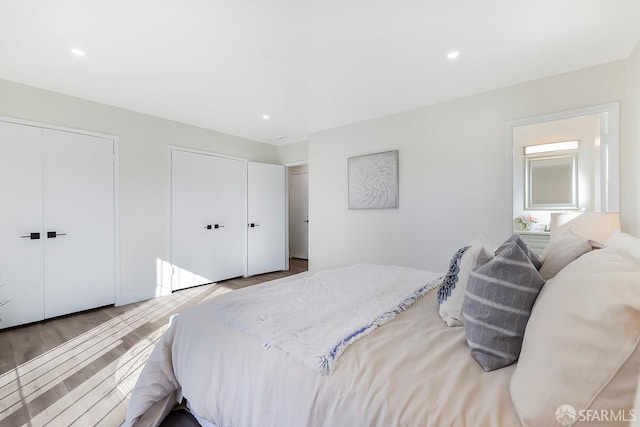 bedroom featuring hardwood / wood-style flooring and multiple closets