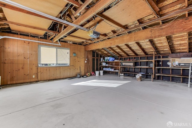 garage with wooden walls and a garage door opener