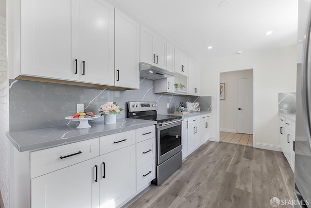 kitchen with white cabinets, light hardwood / wood-style floors, stainless steel range with electric cooktop, and tasteful backsplash