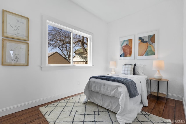 bedroom with baseboards and wood finished floors