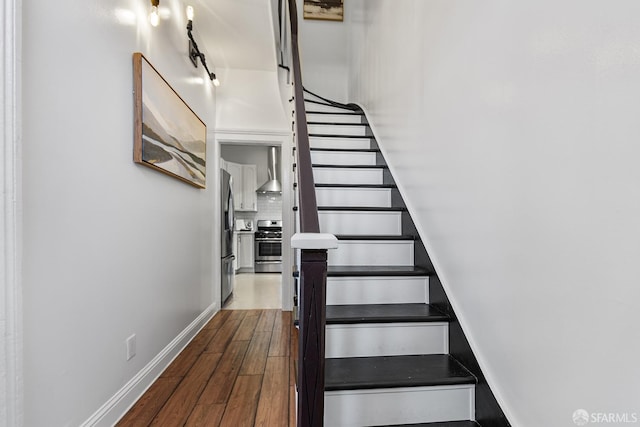 stairway featuring baseboards and wood finished floors