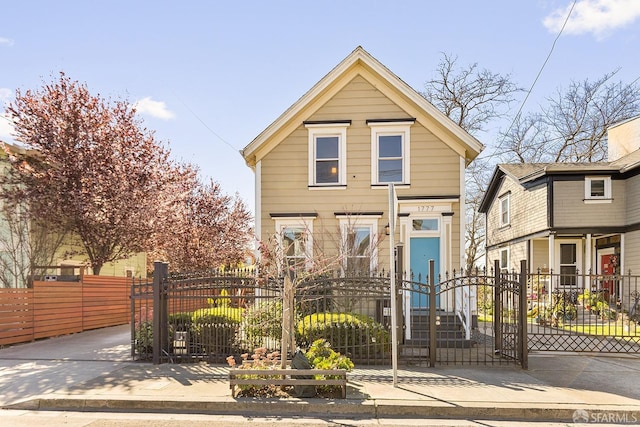 shotgun-style home featuring a gate and a fenced front yard