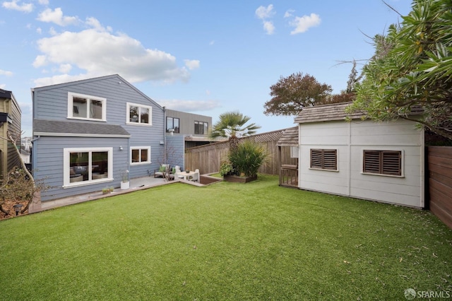 back of house featuring an outdoor structure and a lawn