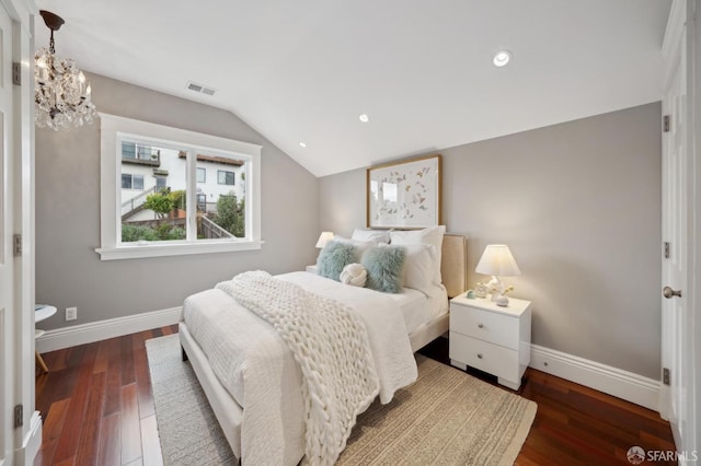 bedroom with an inviting chandelier, dark hardwood / wood-style flooring, and vaulted ceiling