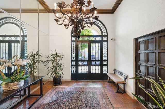 foyer with a notable chandelier, baseboards, a wealth of natural light, and crown molding