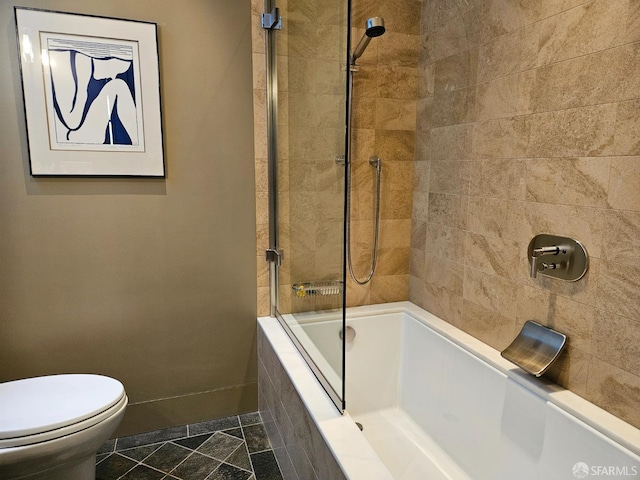 bathroom with tile patterned flooring, toilet, and bath / shower combo with glass door