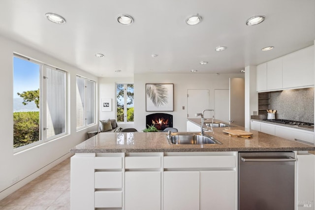 83 Mount Tiburon Rd, Tiburon, CA 94920 - kitchen with a warm lit fireplace, recessed lighting, a center island with sink, open floor plan, and white cabinetry