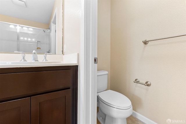 full bathroom featuring toilet, a shower, vanity, and baseboards